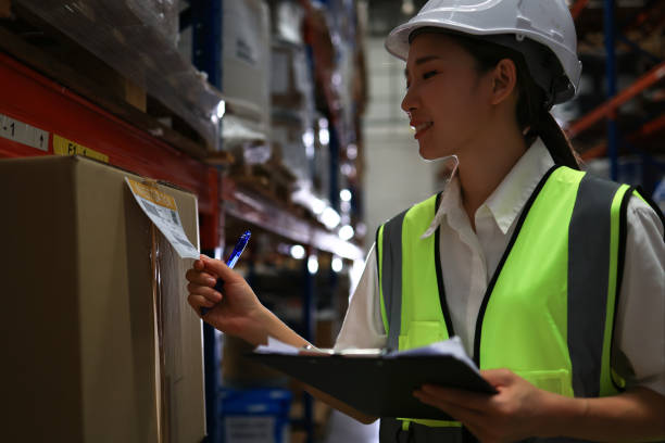 istock female logistic engineer working in warehouses use digital table to ensure the quality of cartons packaged on racks or shelves, Logistics, Import, Export, and Distribution warehouse. 2010262795
