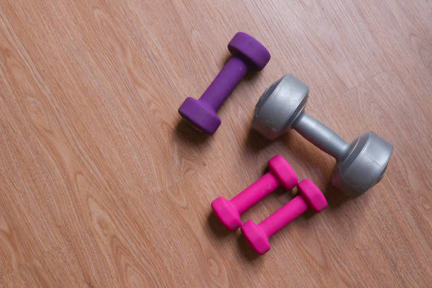 istock dumbbells with plastic coating on a wooden background 2010290855
