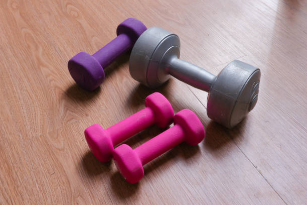 dumbbells with plastic coating on a wooden background