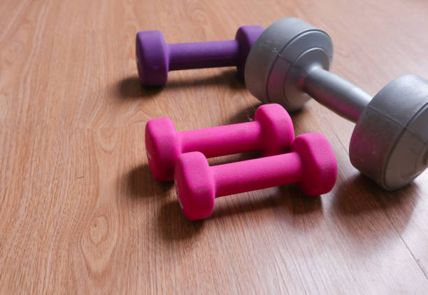 istock dumbbells with plastic coating on a wooden background 2010292008