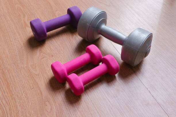 dumbbells with plastic coating on a wooden background