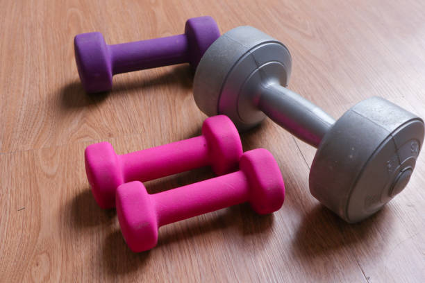 istock dumbbells with plastic coating on a wooden background 2010292054