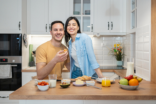 Portrait of an young Caucasian couple, making an breakfast in their modern kitchen