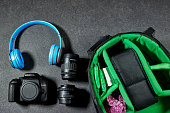 Professional Photography Gear : camera and lenses, blue wireless headphone on grunge gray background