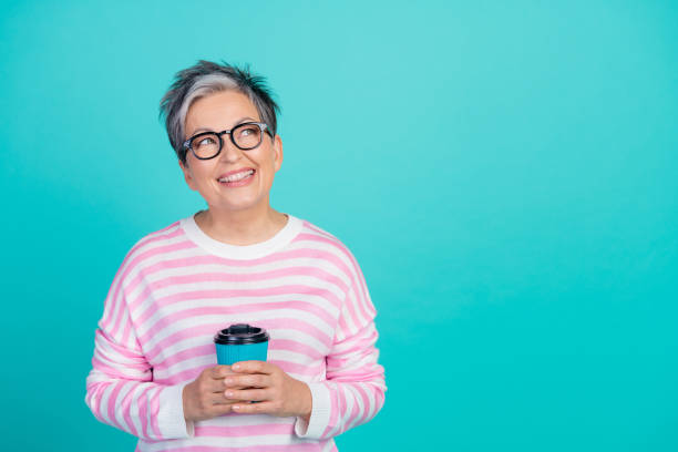 istock Photo of funky thoughtful woman dressed pink pullover drinking cacao looking empty space isolated teal color background 2010304582