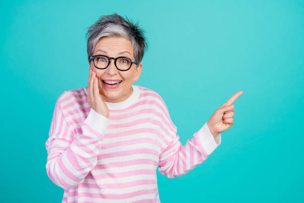 istock Photo of excited funky woman dressed pink pullover eyewear pointing finger empty space isolated teal color background 2010305131