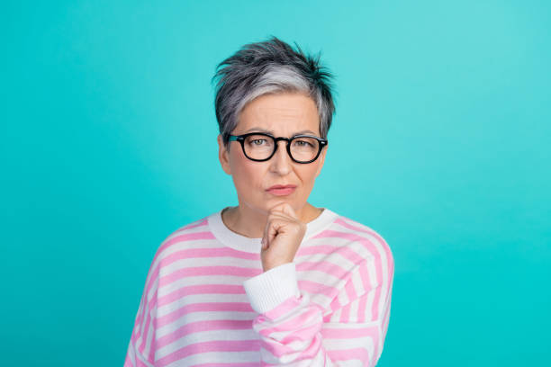 istock Photo of doubtful unsure woman dressed pink pullover eyewear hand arm chin empty space isolated teal color background 2010306730
