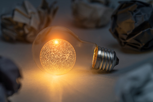 Artificial intelligence concept with classic light bulb glowing in the dark. This file is cleaned and retouched.