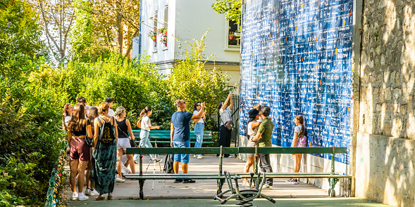 Paris, France - September 10, 2023 : Tourists visiting the Wall of Love, or Mur des Je T'aime, in Montmartre in Paris, France