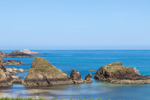 istock a serene coastal landscape with rocky formations, clear blue sky, and calm turquoise waters 2010356424
