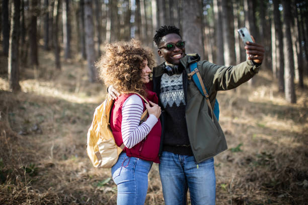 istock Smiling young couple hiking through the forest and making a selfie. 2010362908