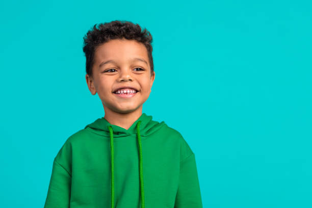 Photo of toothy beaming optimistic schoolboy dressed green pullover look at discount empty space isolated on teal color background