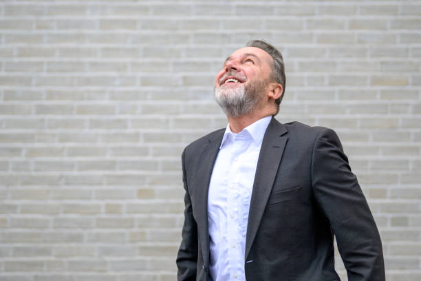 istock Attractive sixty year old gray man looking up with a big smile 2010397250