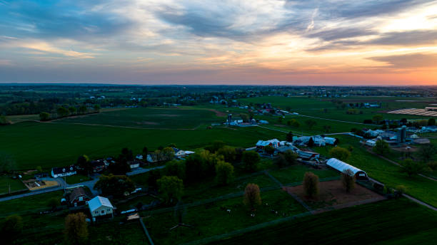 istock Sunset Casts A Warm Glow Over A Rural Farmland Tapestry With Homes, Barns, A Dynamic Sky. 2010399954