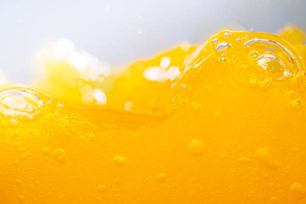 Close up bright orange juice splash texture for health and nature waves, Beautiful waves curve and little bubbles smooth for garphic design and background