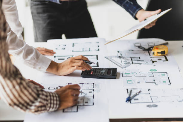 istock Architects work together to design a blueprint and plan a construction project budget. 2010415392