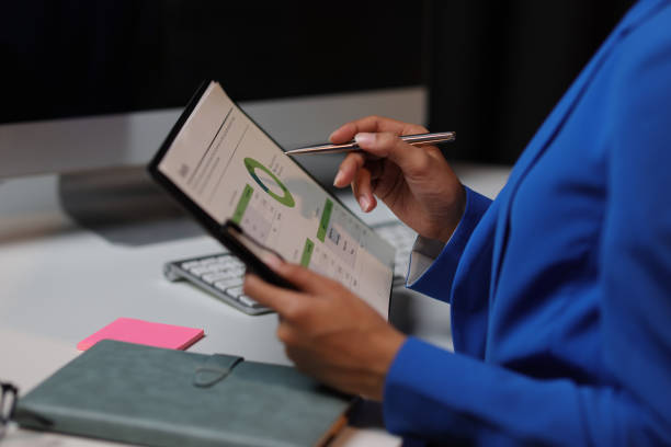 istock Businesswoman working overtime in office, she is analyzing financial figures data chart in business report document. 2010417601