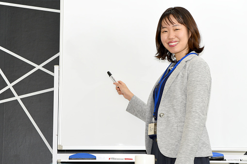 Young Asian businessman giving presentation on whiteboard