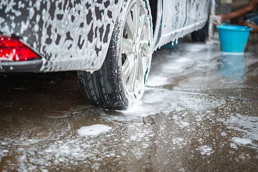active foam soap for car washing. removing dirt from a tire. Concept for a business cleaning service.