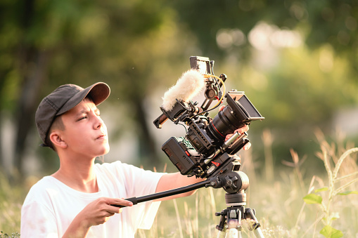 Teenage boys operate a digital camera with daylight to tell the story in a new movie or documentary. content creator, and young filmmaker.