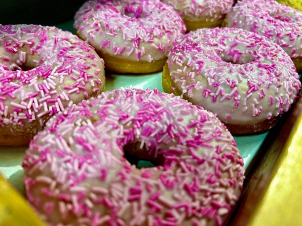 istock A row of pink sprinkle sweet ring doughnuts 2010465839
