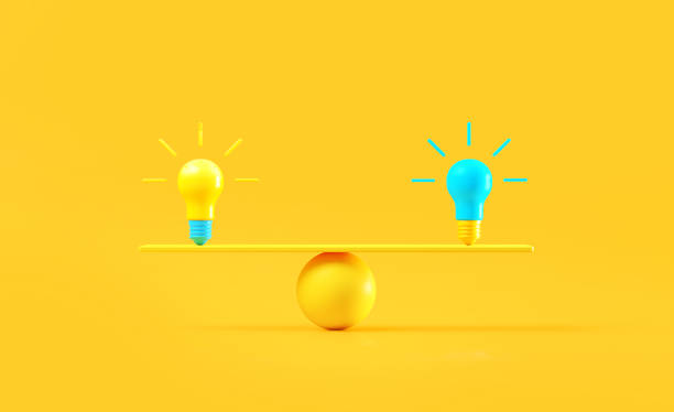 istock Blue And Yellow Light Bulbs On A Yellow Seesaw Over Yellow Background 2010481306