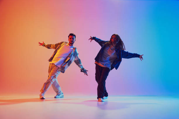 istock Two dancers, man and woman dancing in motion against gradient studio background. Dynamic movement. 2010497911