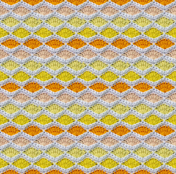 Seamless knitted texture. The pattern in the form of honeycombs is crocheted from colored cotton yarn. Shell design.