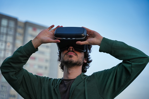 Man Holding VR Headset at Twilight