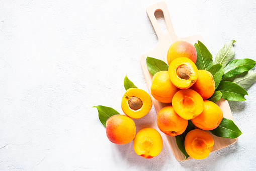 Full frame of fresh apricots with half slice. Close-up of ripe apricots.