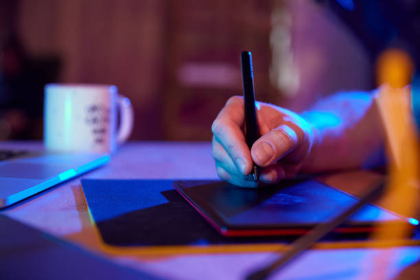 istock Male hand drawing on digital drawing pad in vibrant, illuminated workspace. Content creator and creative occupation. 2010540056