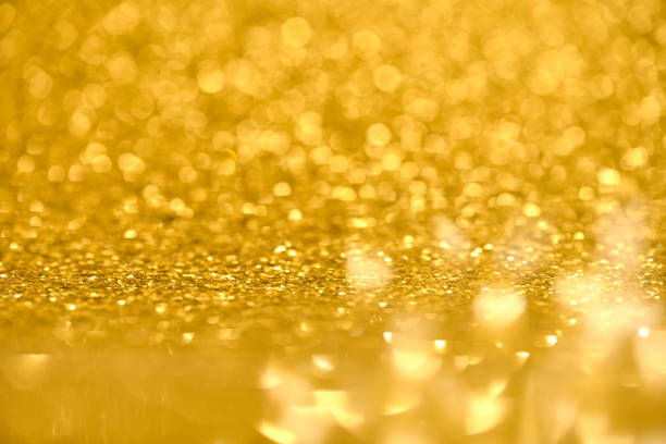 Defocused golden sequin light. Fancy gold glitter sparkle background. Studio shooting of a creative bright yellow color background. It is textured color gradient. There are no text and no people, and have copy space for design. Its Suitable for commercial use. Christmas, New Year, Diwali festive celebrations themed backgrounds, wallpapers, templates for greeting cards, banners and posters and wrapping paper is apt.