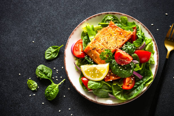 istock Green salad with salmon fillet on black. 2010552839