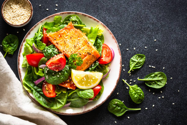 istock Green salad with salmon fillet on black. 2010552850