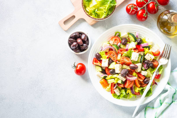 istock Greek salad with olives at white. 2010555441