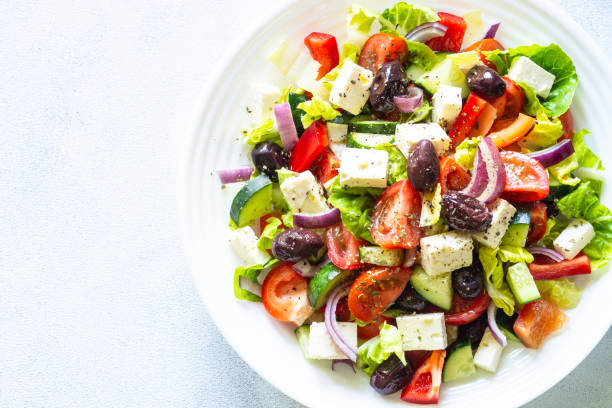 istock Greek salad with olives at white. 2010555624