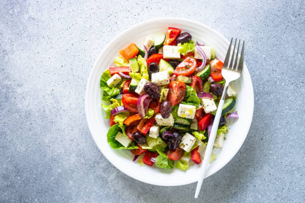 istock Greek salad with olives at white. 2010555972