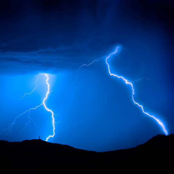 istock Lightning Bolts on Mountain with Radio Tower Blue Sky 2010572883