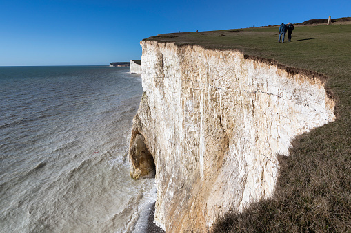 Eastbourne, UK - Feb 12, 2024: People walking the coast path above the Seven Sisters cliffs in Sussex England UK.