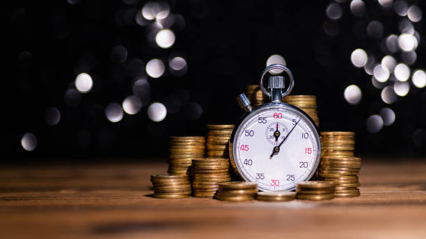 coin stacks with a stopwatch - watch old fashioned banking coin 뉴스 사진 이미지