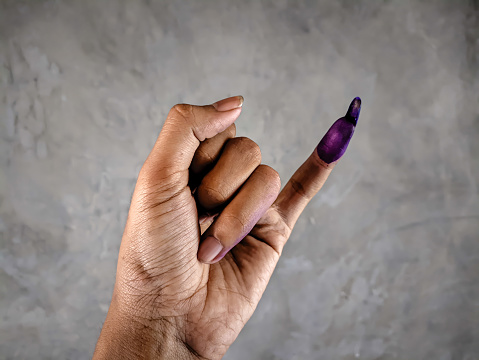 Showing a hand with purple ink on the little finger after the Indonesian presidential election or the 2024 election