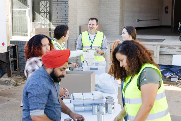 istock Diverse adults volunteer to sort donations at warehouse 2010606317