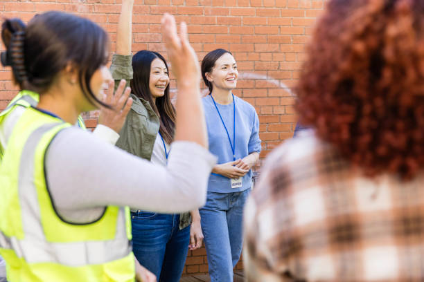 istock Diverse adults raise hands to volunteer 2010606831