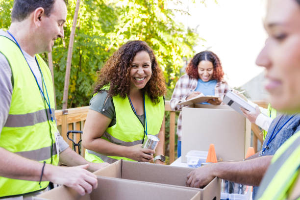 istock Diverse volunteers smile and laugh while sorting food into boxes 2010606860