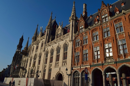 Bruges, Belgium - June 8 2023: Historic market square in the centre of Bruges, the capital of West Flanders in northwest Belgium. Known for its beautiful canals, cobbled streets and medieval buildings