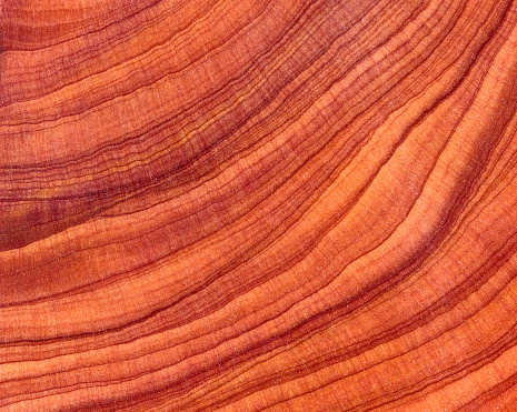 The wood is red and brown color with layers and lines like a rose petal. High angle view of a flat textured wooden board backgrounds. It has a beautiful nature and abstractive pattern. A close-up studio shooting shows details and lots of wood grain on the wood table. The piece of wood at the surface of the table also appears rich wooden material on it, shows elegant and soft textured. Flat lay style. Its high-resolution textured quality.5