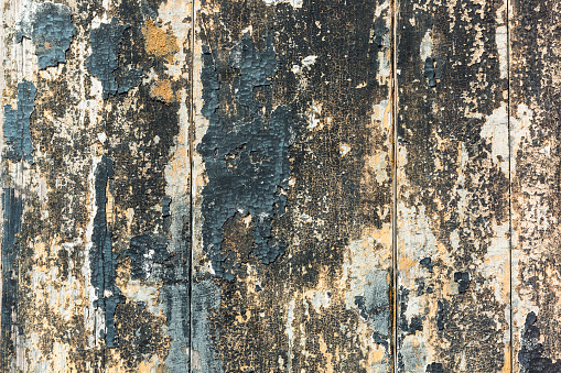 Weathered and scratched rustic wooden board.High angle view of a flat textured wooden board backgrounds. It has a beautiful nature and abstractive pattern. A close-up studio shooting shows details and lots of wood grain on the wood table. The piece of wood at the surface of the table also appears rich wooden material on it. The wood is dark brown color with darker brown lines and pattern on the bottom. Flat lay style. Its high-resolution textured quality.The close-up gives a direct view on the table, showing cracks and knotholes in the wood.