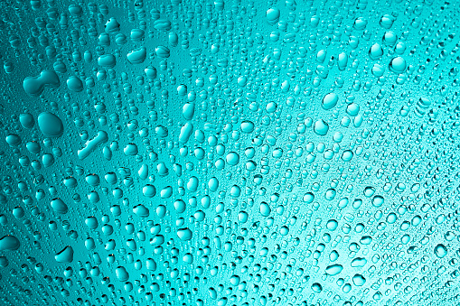 close up of water droplet on blue background