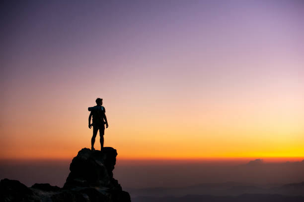 istock Hikers silhouette on big rock against sunset sky 2010703438