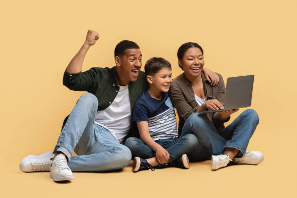 istock Happy family using laptop on beige background 2010725074